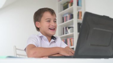 Bilgisayarlı küçük okul çocuğu, internetten uzaktan öğreniyor.