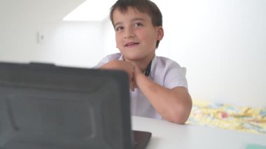 Bilgisayarlı küçük okul çocuğu, internetten uzaktan öğreniyor.