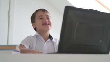 Bilgisayarlı küçük okul çocuğu, internetten uzaktan öğreniyor.