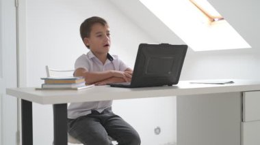 Bilgisayarlı küçük okul çocuğu, internetten uzaktan öğreniyor.