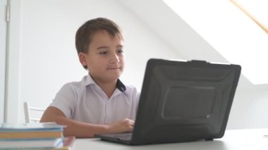 Bilgisayarlı küçük okul çocuğu, internetten uzaktan öğreniyor.