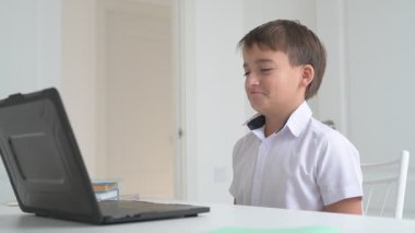 Bilgisayarlı küçük okul çocuğu, internetten uzaktan öğreniyor.