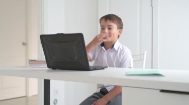 Bilgisayarlı küçük okul çocuğu, internetten uzaktan öğreniyor.