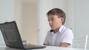 Bilgisayarlı küçük okul çocuğu, internetten uzaktan öğreniyor.