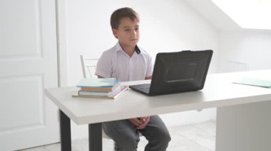 Bilgisayarlı küçük okul çocuğu, internetten uzaktan öğreniyor.