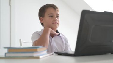 Bilgisayarlı küçük okul çocuğu, internetten uzaktan öğreniyor.
