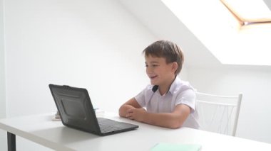 Bilgisayarlı küçük okul çocuğu, internetten uzaktan öğreniyor.