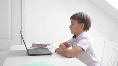 Bilgisayarlı küçük okul çocuğu, internetten uzaktan öğreniyor.