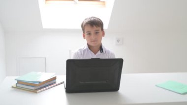 Bilgisayarlı küçük okul çocuğu, internetten uzaktan öğreniyor.