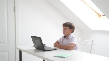 Bilgisayarlı küçük okul çocuğu, internetten uzaktan öğreniyor.