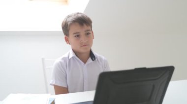 Bilgisayarlı küçük okul çocuğu, internetten uzaktan öğreniyor.