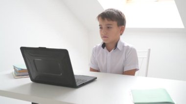 Bilgisayarlı küçük okul çocuğu, internetten uzaktan öğreniyor.