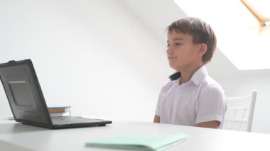 Bilgisayarlı küçük okul çocuğu, internetten uzaktan öğreniyor.