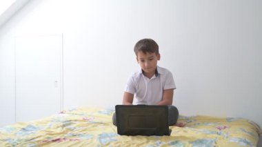 Bilgisayarlı küçük okul çocuğu, internetten uzaktan öğreniyor.