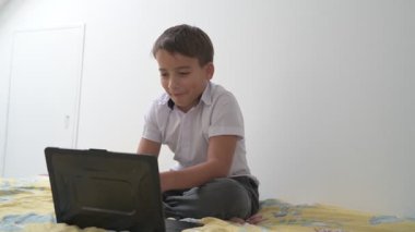 Bilgisayarlı küçük okul çocuğu, internetten uzaktan öğreniyor.