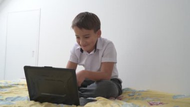 Bilgisayarlı küçük okul çocuğu, internetten uzaktan öğreniyor.