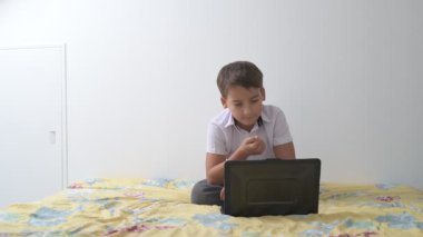 Bilgisayarlı küçük okul çocuğu, internetten uzaktan öğreniyor.