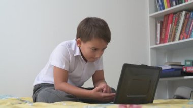 Bilgisayarlı küçük okul çocuğu, internetten uzaktan öğreniyor.