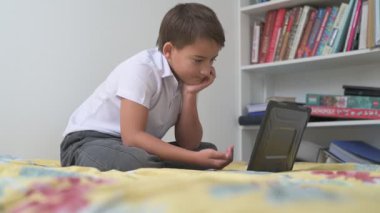 Bilgisayarlı küçük okul çocuğu, internetten uzaktan öğreniyor.