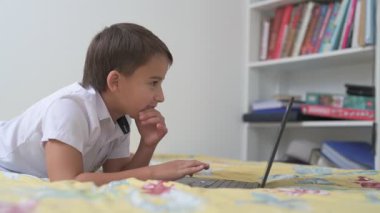 Bilgisayarlı küçük okul çocuğu, internetten uzaktan öğreniyor.