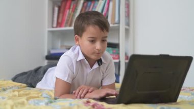 Bilgisayarlı küçük okul çocuğu, internetten uzaktan öğreniyor.