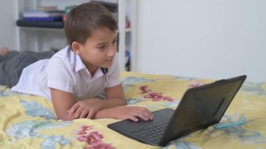 Bilgisayarlı küçük okul çocuğu, internetten uzaktan öğreniyor.