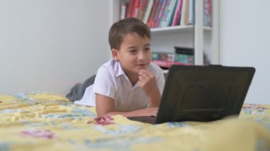 Bilgisayarlı küçük okul çocuğu, internetten uzaktan öğreniyor.