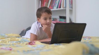 Bilgisayarlı küçük okul çocuğu, internetten uzaktan öğreniyor.