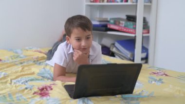 Bilgisayarlı küçük okul çocuğu, internetten uzaktan öğreniyor.