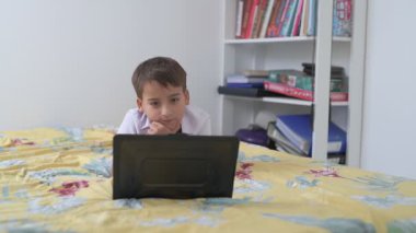 Bilgisayarlı küçük okul çocuğu, internetten uzaktan öğreniyor.