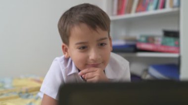 Bilgisayarlı küçük okul çocuğu, internetten uzaktan öğreniyor.