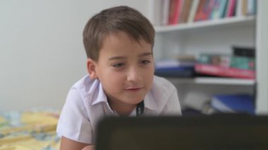 Bilgisayarlı küçük okul çocuğu, internetten uzaktan öğreniyor.