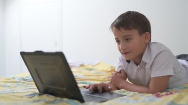 Bilgisayarlı küçük okul çocuğu, internetten uzaktan öğreniyor.