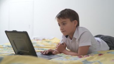 Bilgisayarlı küçük okul çocuğu, internetten uzaktan öğreniyor.