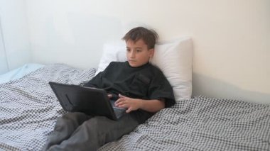 Bilgisayarlı küçük okul çocuğu, internetten uzaktan öğreniyor.