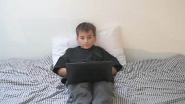 Bilgisayarlı küçük okul çocuğu, internetten uzaktan öğreniyor.