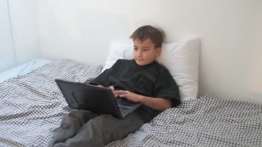 Bilgisayarlı küçük okul çocuğu, internetten uzaktan öğreniyor.