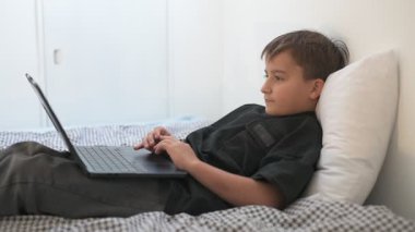 Bilgisayarlı küçük okul çocuğu, internetten uzaktan öğreniyor.