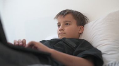 Bilgisayarlı küçük okul çocuğu, internetten uzaktan öğreniyor.