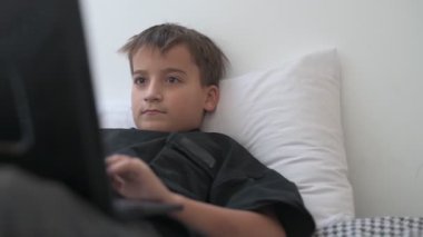 Bilgisayarlı küçük okul çocuğu, internetten uzaktan öğreniyor.