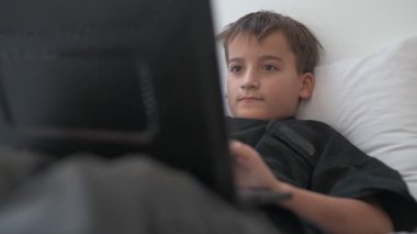 Bilgisayarlı küçük okul çocuğu, internetten uzaktan öğreniyor.