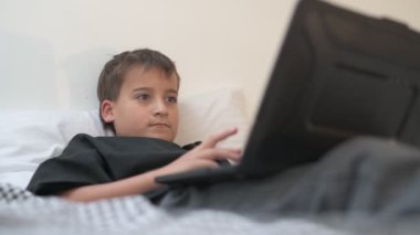 Bilgisayarlı küçük okul çocuğu, internetten uzaktan öğreniyor.