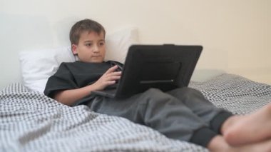 Bilgisayarlı küçük okul çocuğu, internetten uzaktan öğreniyor.