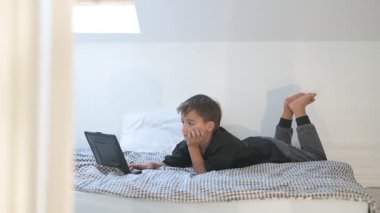 Bilgisayarlı küçük okul çocuğu, internetten uzaktan öğreniyor.