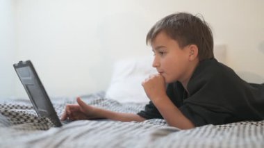 Bilgisayarlı küçük okul çocuğu, internetten uzaktan öğreniyor.