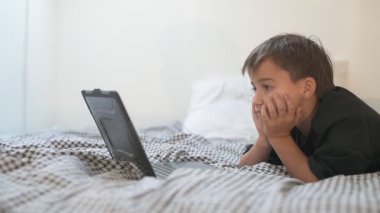 Bilgisayarlı küçük okul çocuğu, internetten uzaktan öğreniyor.