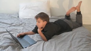 Bilgisayarlı küçük okul çocuğu, internetten uzaktan öğreniyor.