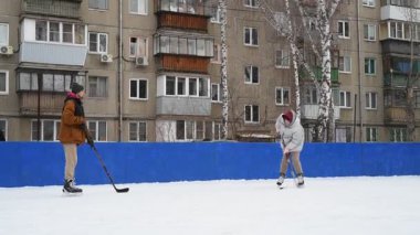 İnsanlar bahçede buz hokeyi oynuyorlar.