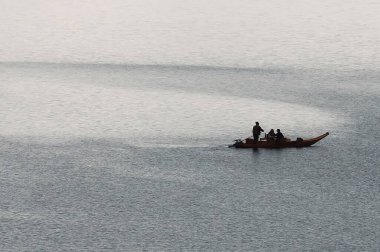 Bir balıkçıyla nehirde bir tekne.
