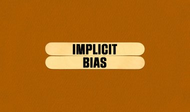 Implicit Bias Symbol. Concept word Implicit Bias on beautiful wooden stick. Beautiful Orange Chart Paper Background. Business and Implicit Bias concept. Copy space clipart